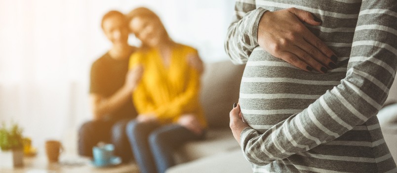 Happy couple looking at pregnant woman 