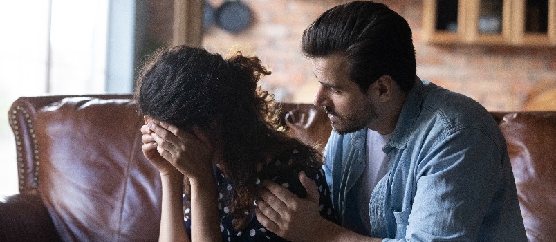 Loving young man comforting girlfriend 