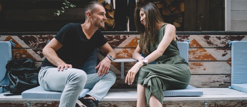 Couple talking sitting on bench 