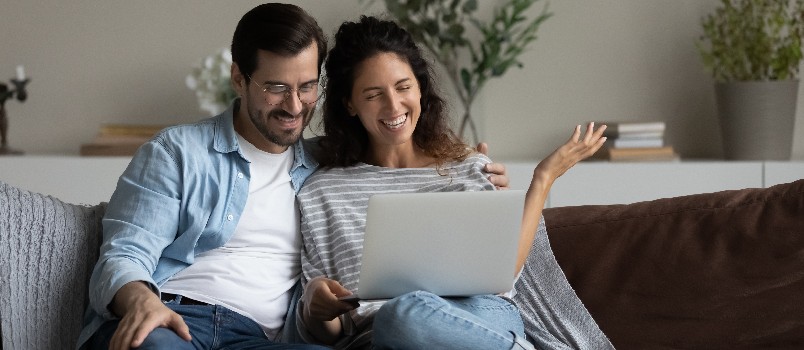 Happy couple using laptop