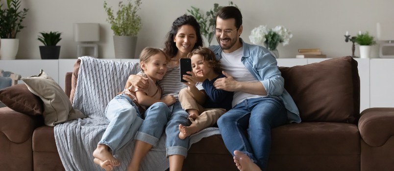 happy parents two kids-using smartphone-