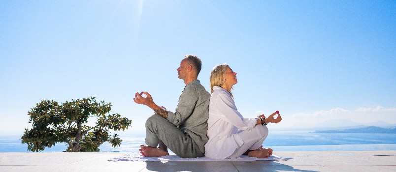 Couple doing meditation beside beach