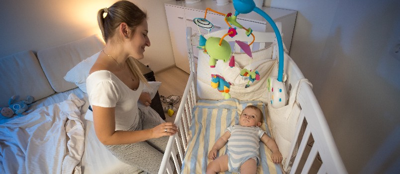 Beautifully mother siting next to baby