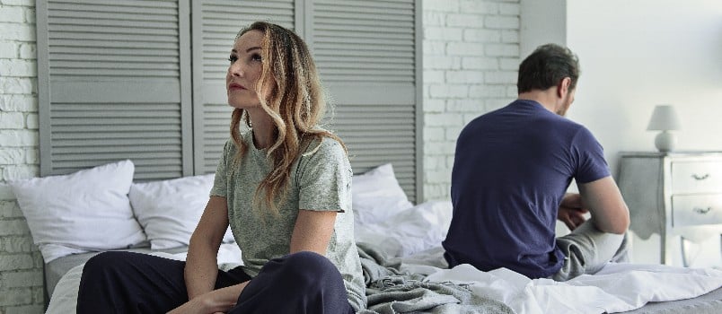 Couple sitting in bedroom having conflicts 