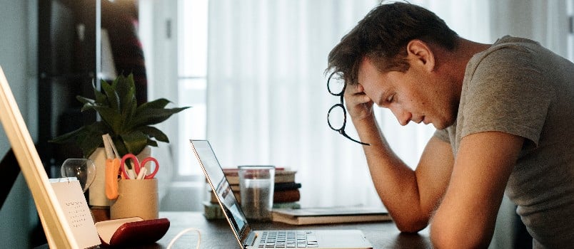 Depressed man sitting in front of laptop 