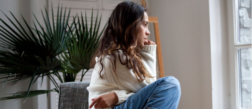 Sad thoughtful girl sitting alone