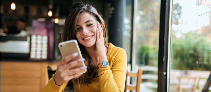 Young smiling woman using smartphone