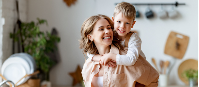 Happy woman piggyback her child