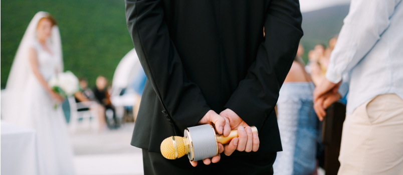 host wedding party stands holds microphone