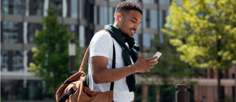 Young man listening to music while walking