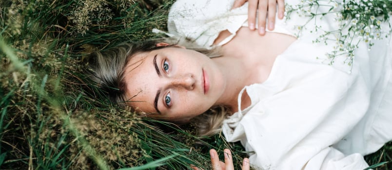 Young bold woman laying on grass 