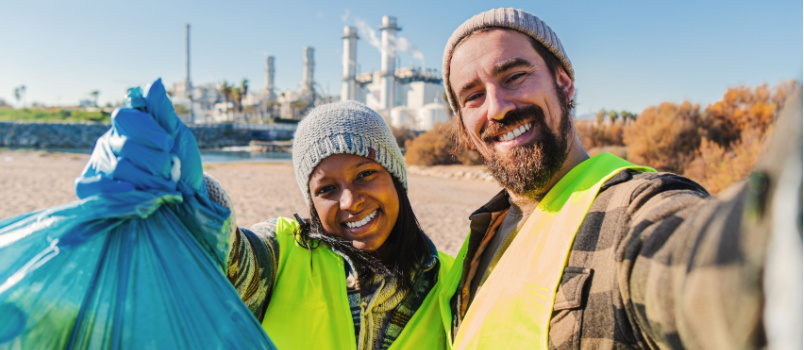 Couple picking up industrial waste cleaning team
