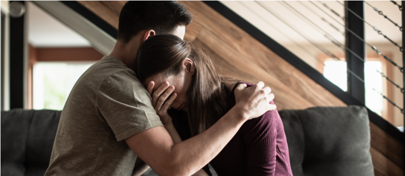 Husband comforting sad crying woman