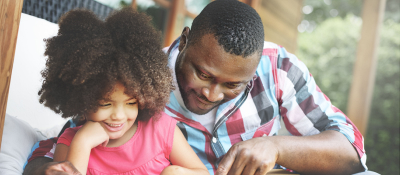 Father and daughter bonding reading book together