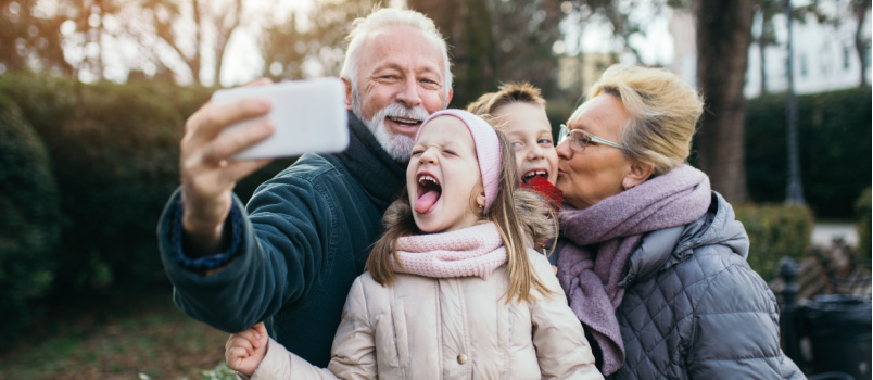 Grandparents taking selfie with grand child