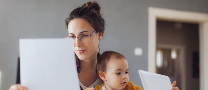 Business woman working while handling baby