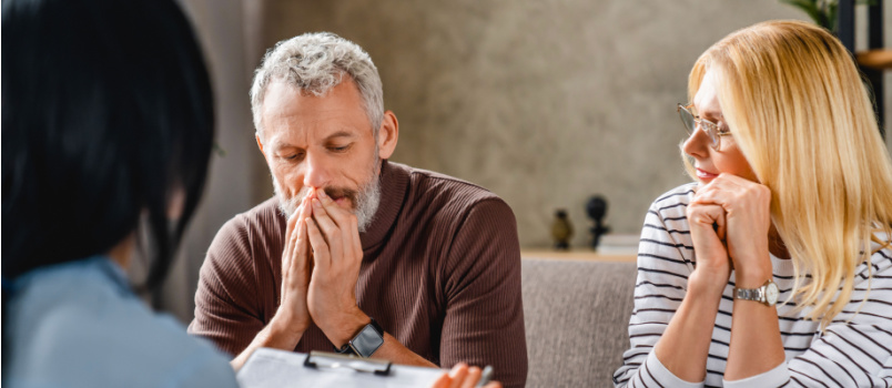 Worried couple sitting on couch