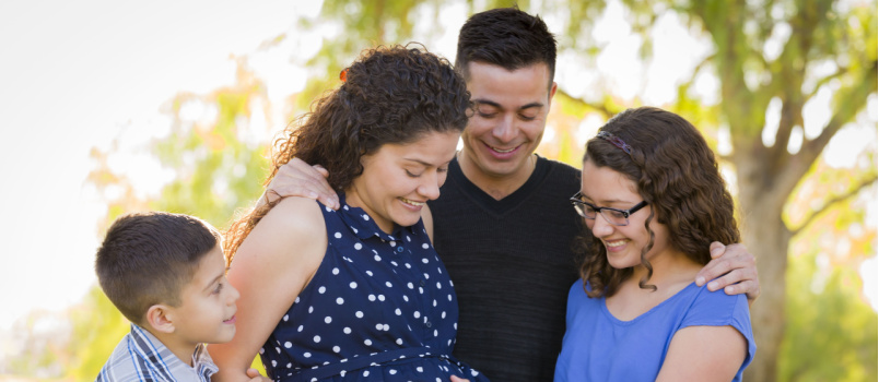 Family hands on pregnant mother womb