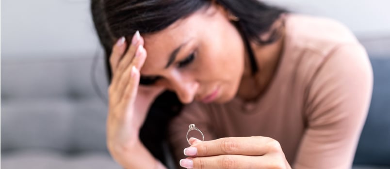 Disappointed woman sitting holding rings