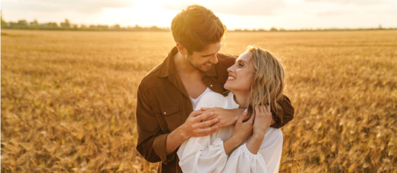 Couple hugging outside in ground