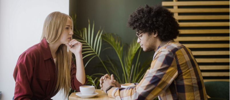 Upset girlfriend and boyfriend sitting in cafe