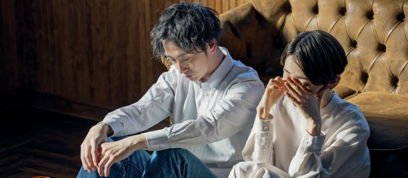 Depressed couple sitting in room