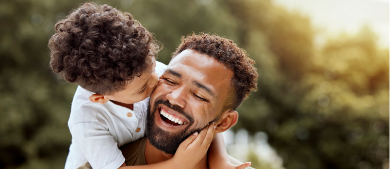 Father bonding boy kisses child