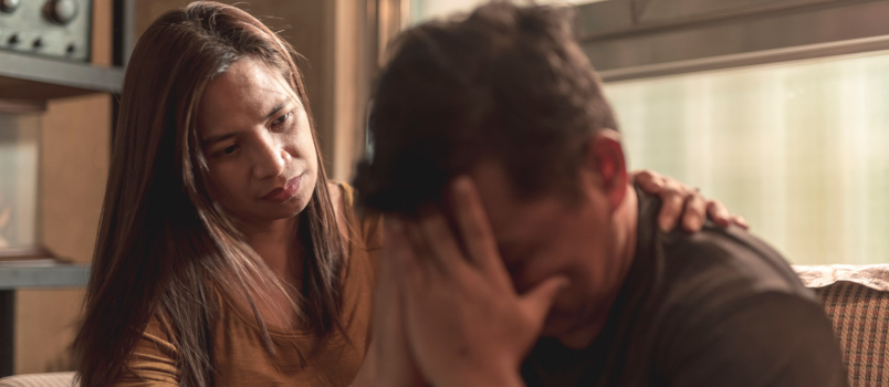 Concerned wife comforting her husband