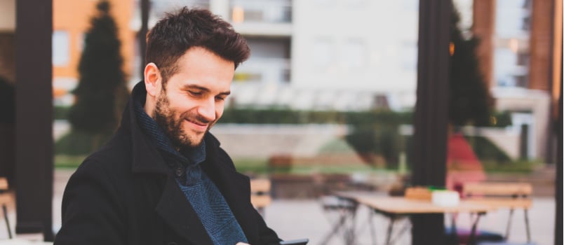 Man sitting in cafe texting