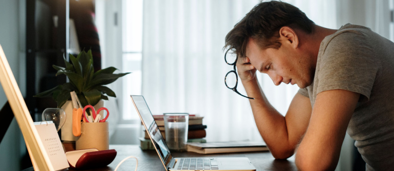 Man stressed while working on laptop