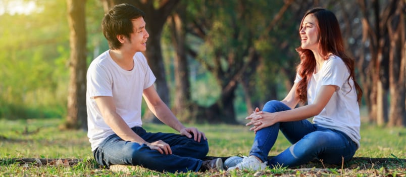 Young couple talking laughing at park