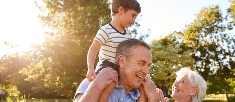 Grandparent giving grandson ride on shoulder