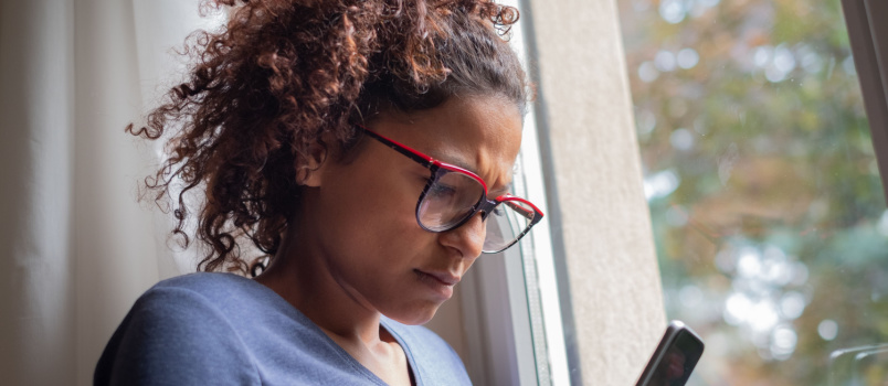 Doubtful woman standing beside window