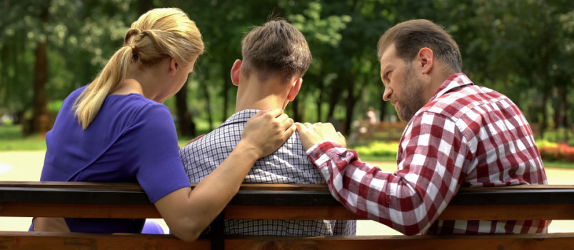 Caring parents supporting sad son