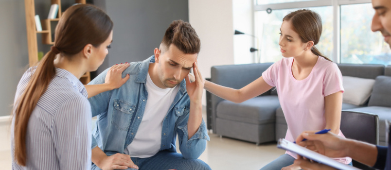 Young people calming sad man
