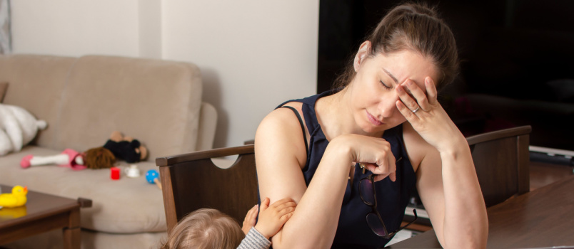 Mother trying to work on laptop