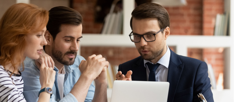 Young couple sitting with real estate agent