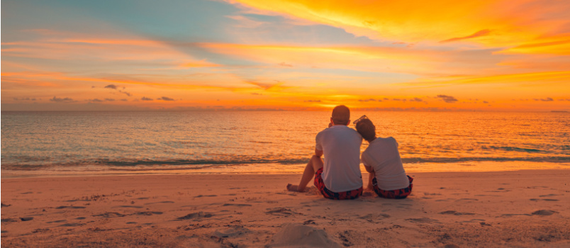 Happy couple sitting on beach