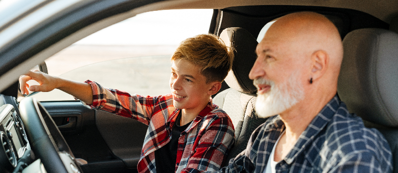 Adolescent et homme âgé chevauchant ensemble dans une voiture