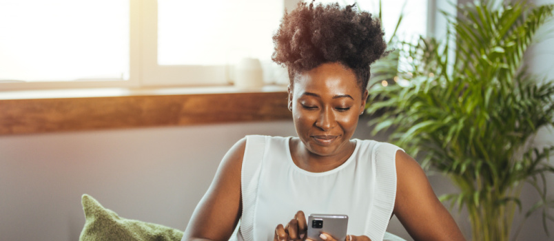 Happy woman texting message on phone