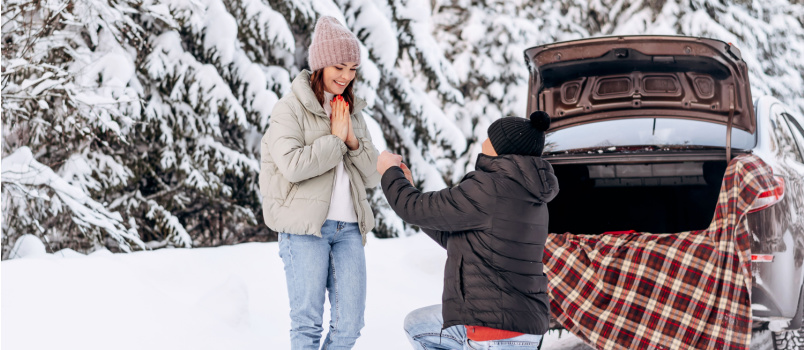 Man proposing woman in snow