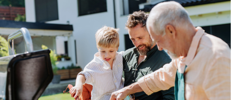 Three generation doing barbeque in backyard