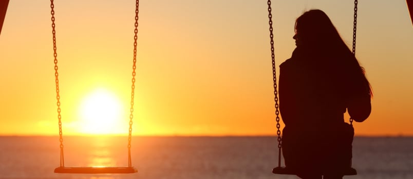 Woman swinging alone on beach