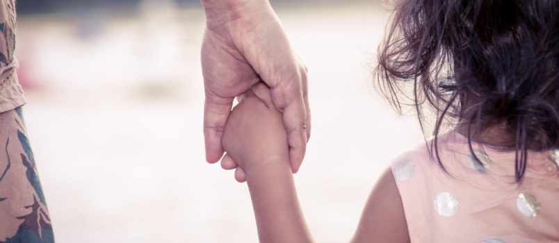 Mother holding cute little child hand