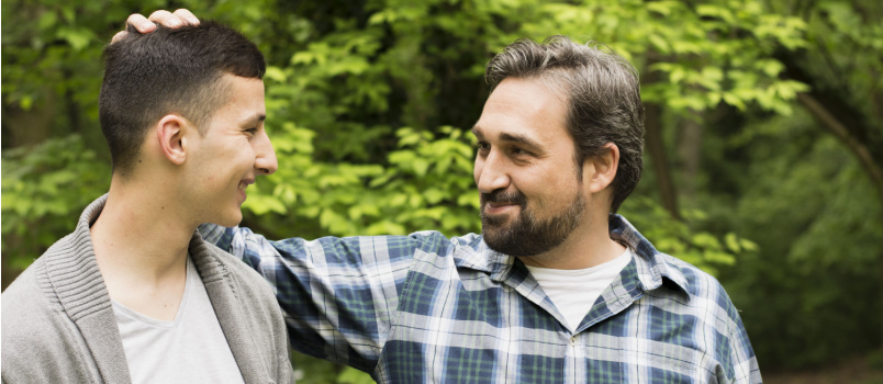 Teenager son walking with father