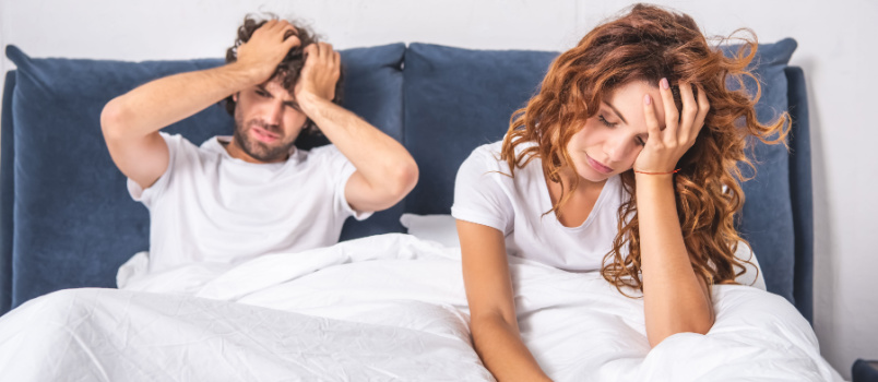 Young couple sitting on bed
