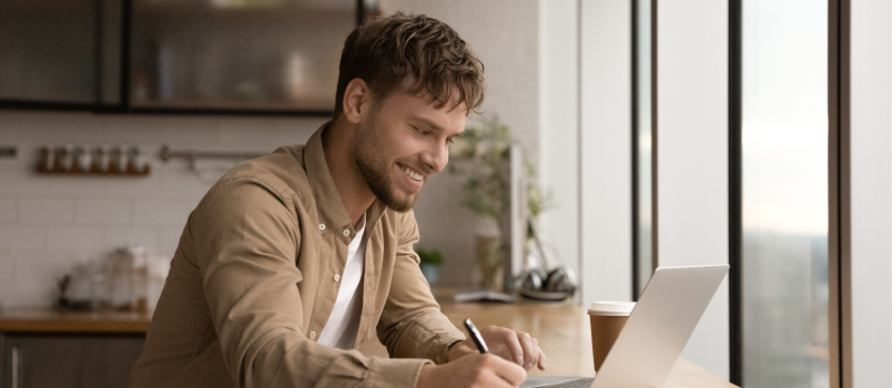 Young smiling man using laptop