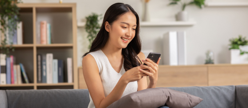 Happy woman texting on phone