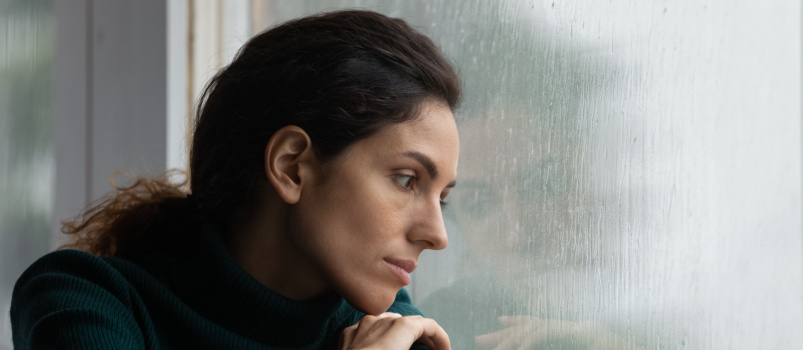 Stressed woman leaning on wall