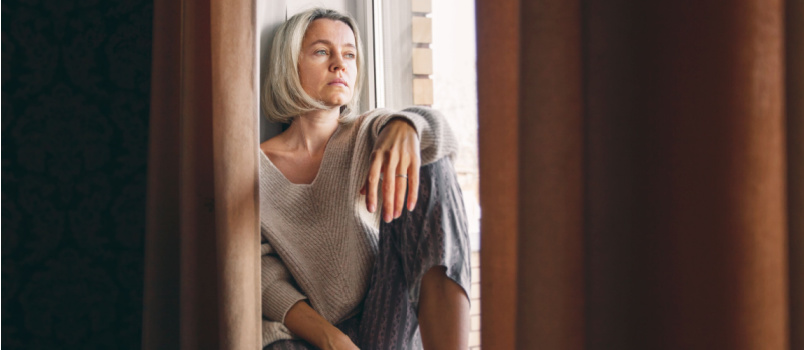 Sad woman looking outside of the window